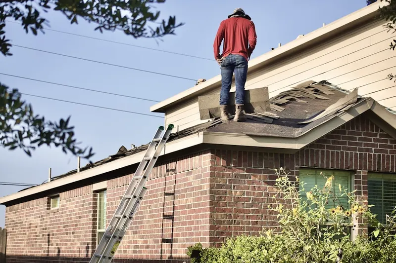 Professional roofer working on a residential roof in Patriot Place